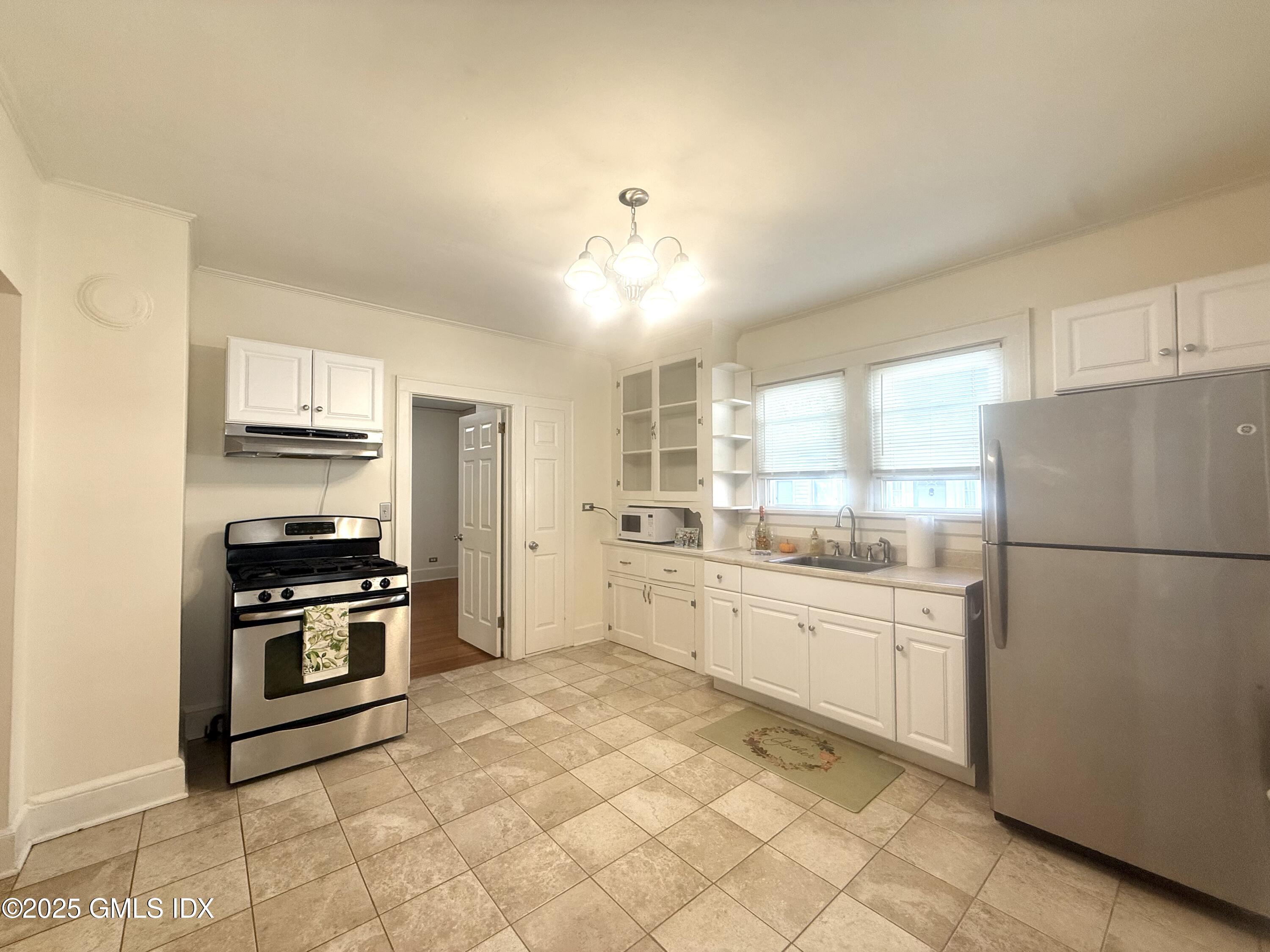 217 River Extension, Unit LOWER LEVEL Cos Cob, CT 06807 - Photo 3 of 16 a kitchen with granite countertop a refrigerator stove top oven and sink