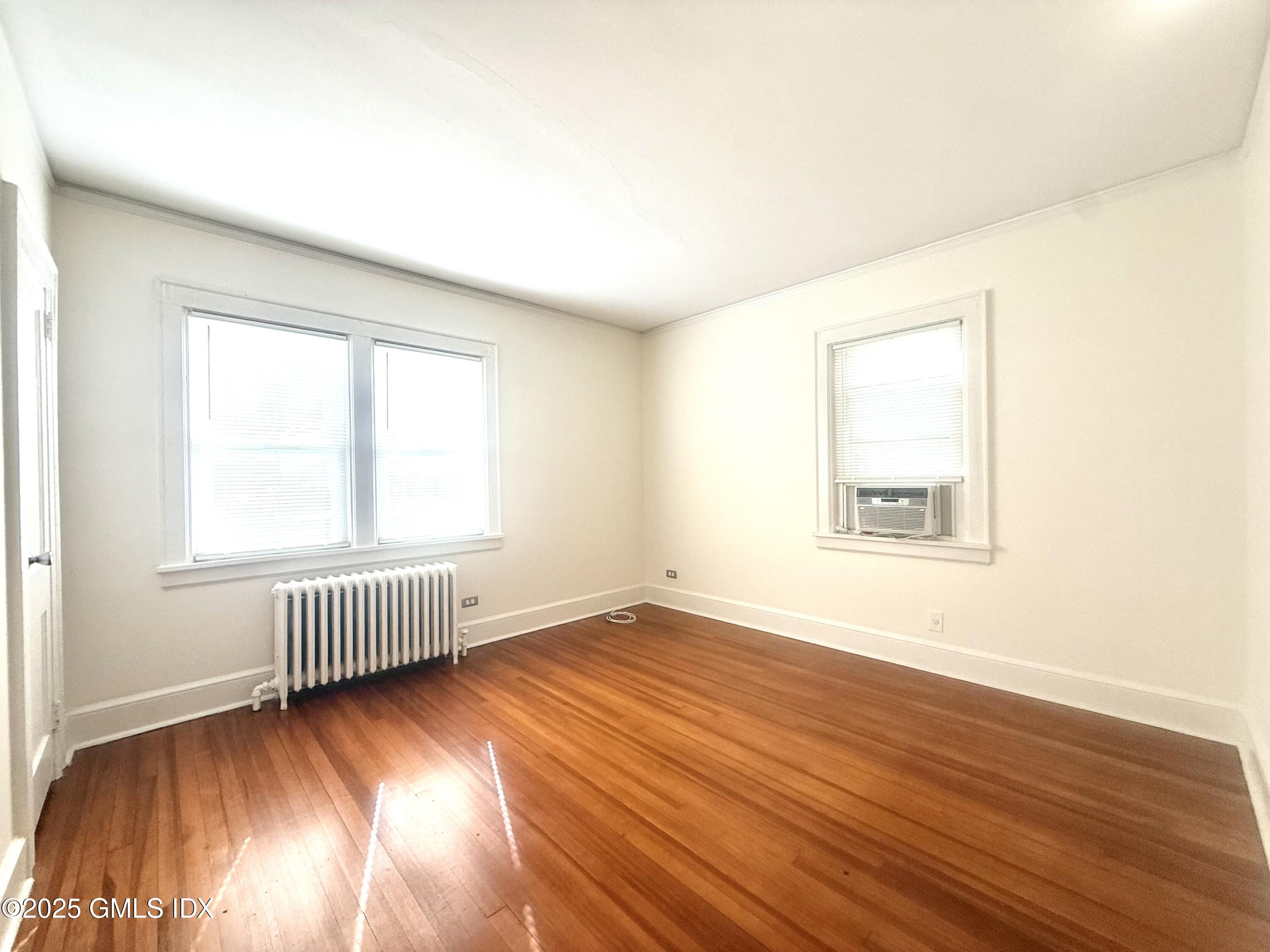 217 River Extension, Unit LOWER LEVEL Cos Cob, CT 06807 - Photo 10 of 16 an empty room with wooden floor and windows