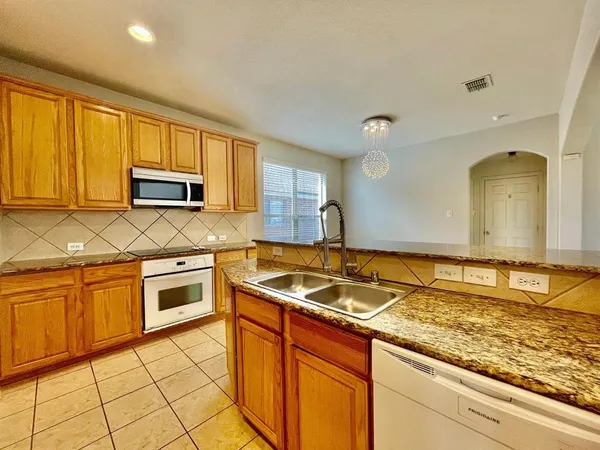 a kitchen with granite countertop a sink stove and cabinets