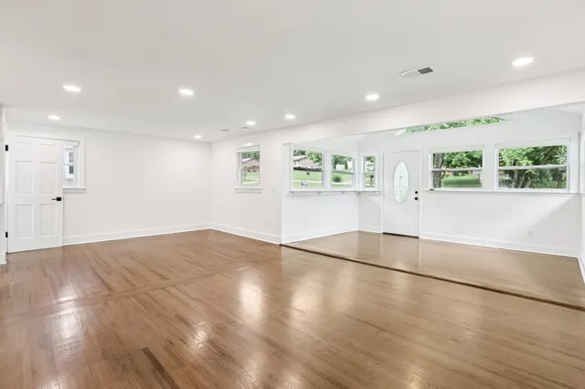 a kitchen with kitchen island granite countertop a sink a stove a refrigerator and island with wooden floor