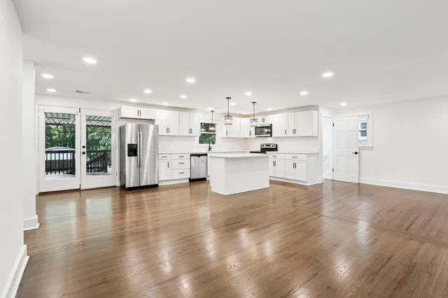 a large kitchen with stainless steel appliances kitchen island a large counter top and a stove top oven