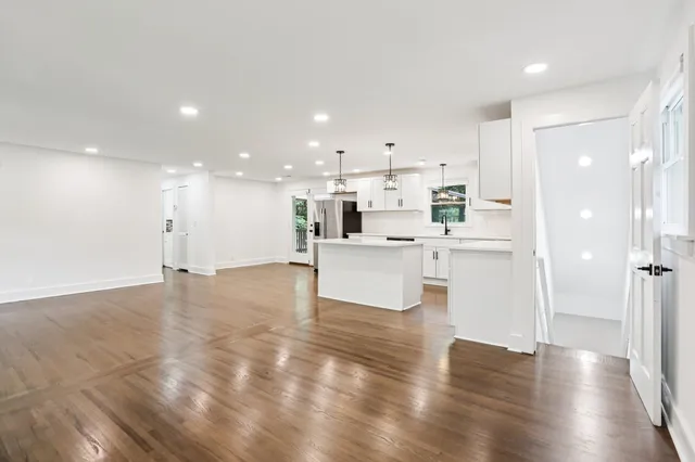 a view of a kitchen with a sink dishwasher a refrigerator and wooden floor