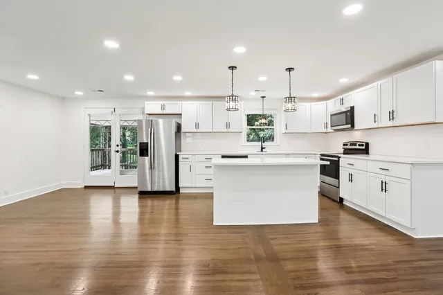 an empty room with wooden floor and window