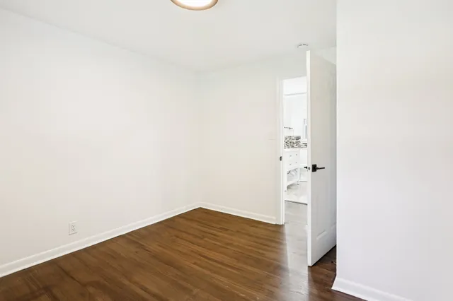 a view of empty room with wooden floor and window