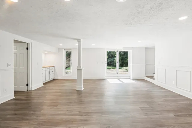 a view of a patio with a table and chairs under an umbrella with a small yard