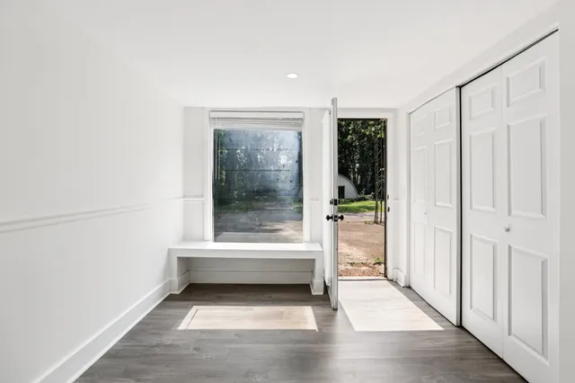 a view of a house with a yard and a large tree
