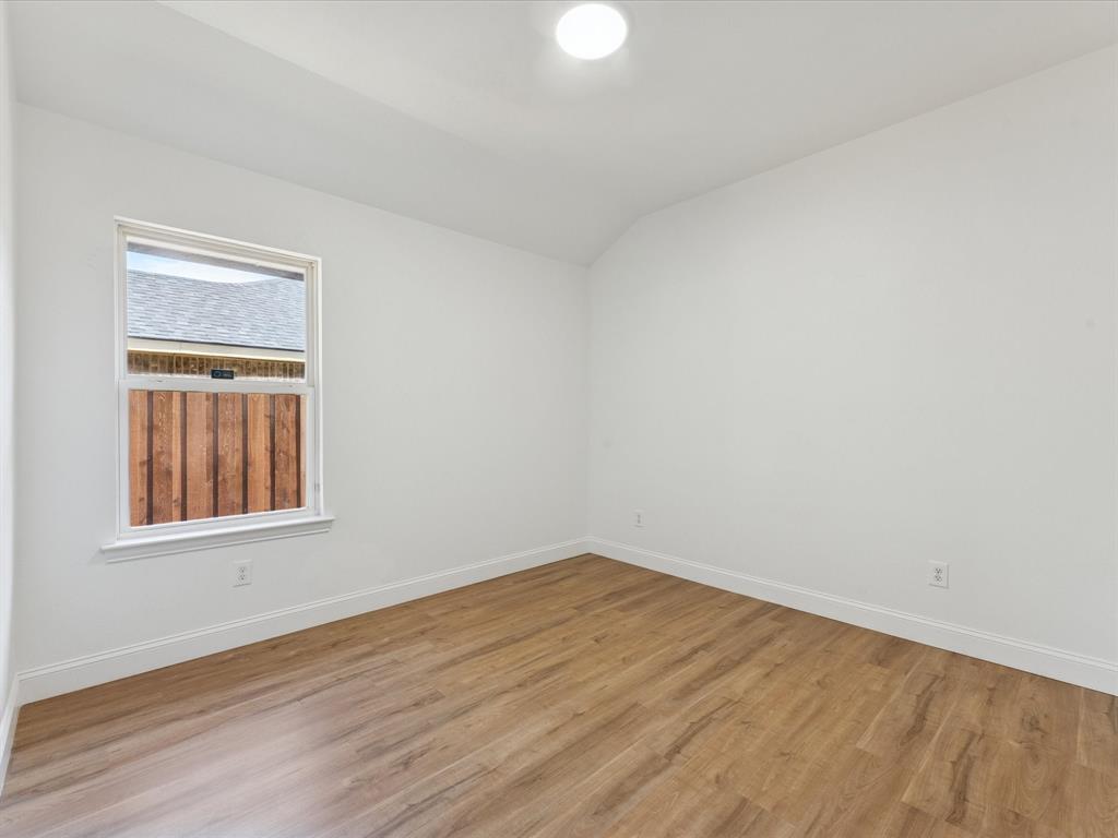 810 Ranch Road Dallas, TX 75253 - Photo 11 of 28 Spare room with wood finished floors and lofted ceiling