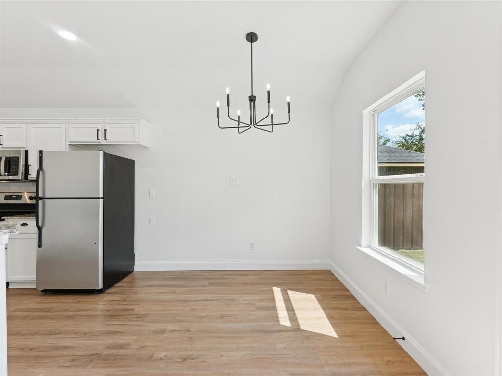 810 Ranch Road Dallas, TX 75253 - Photo 16 of 28 Unfurnished dining area with a chandelier, lofted ceiling, and light wood-style flooring