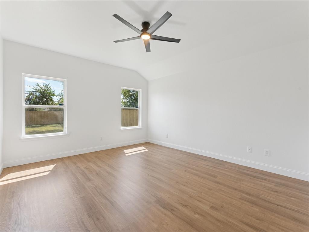 810 Ranch Road Dallas, TX 75253 - Photo 21 of 28 Unfurnished room featuring light wood-style flooring, lofted ceiling, and ceiling fan