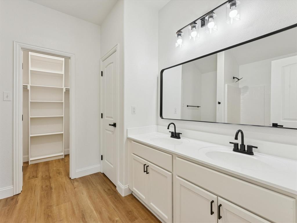 810 Ranch Road Dallas, TX 75253 - Photo 22 of 28 Bathroom featuring double vanity, light wood-style floors, a spacious closet, and a shower