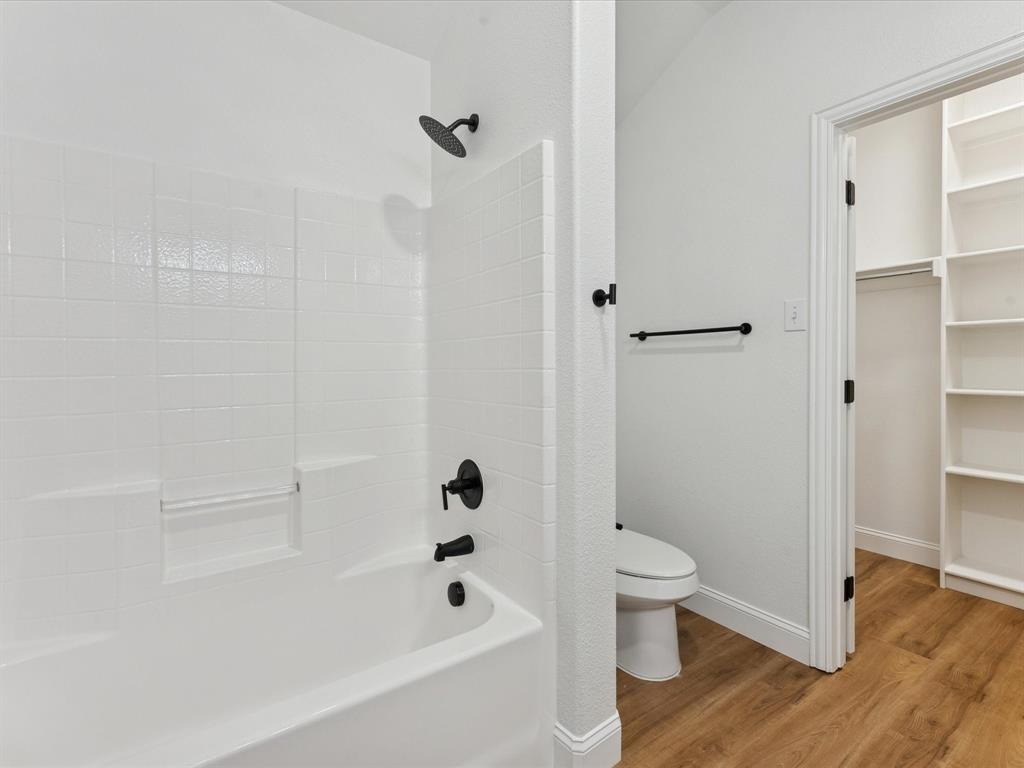 810 Ranch Road Dallas, TX 75253 - Photo 23 of 28 Bathroom featuring shower / bathtub combination, light wood-type flooring, and a spacious closet