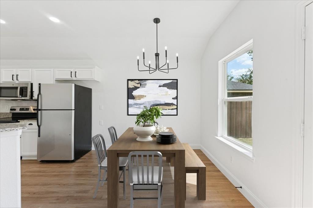 810 Ranch Road Dallas, TX 75253 - Photo 5 of 28 Dining area featuring a chandelier, lofted ceiling, and light wood-style flooring
