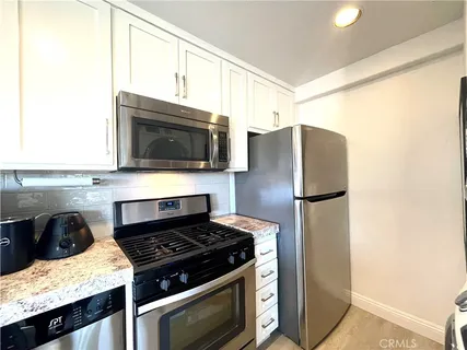 a kitchen with stainless steel appliances a microwave a stove and refrigerator