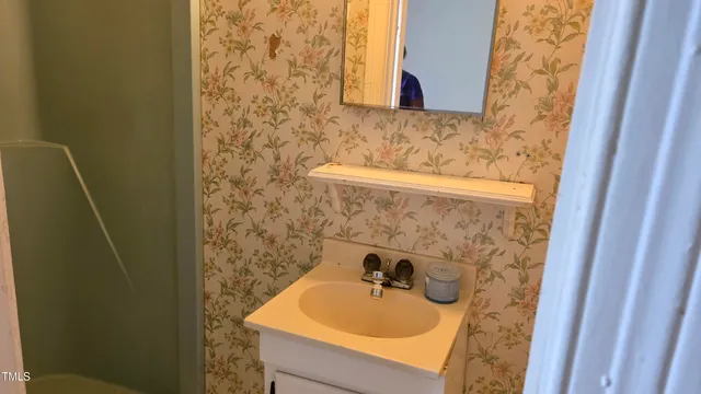a view of a livingroom with wooden floor and kitchen space