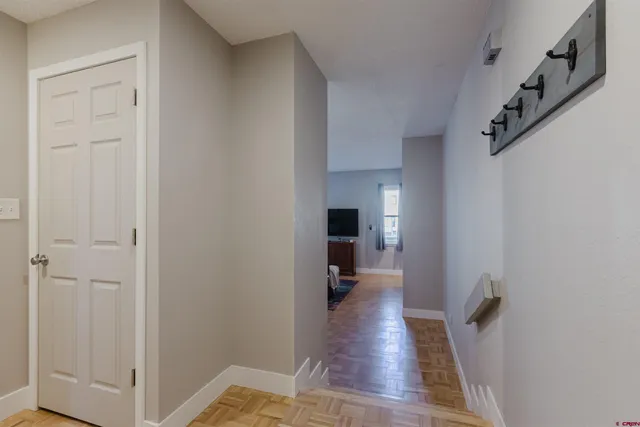 a view of a hallway with wooden floor and staircase