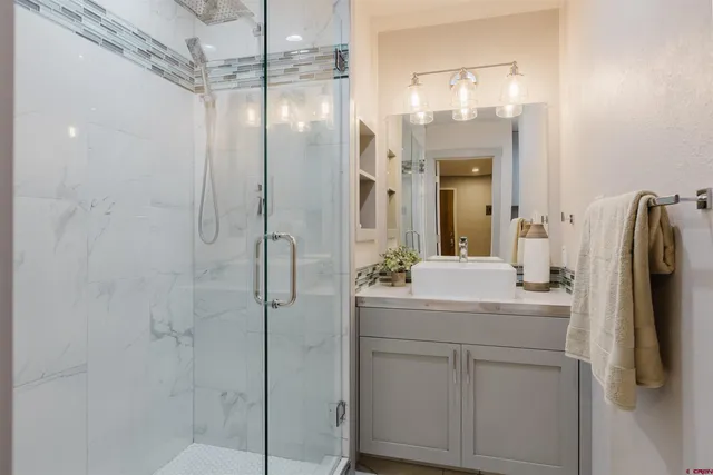 a bathroom with a shower sink and mirror