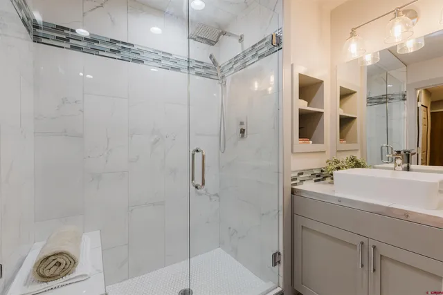 a bathroom with a shower sink vanity and mirror