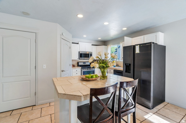 1727 South Sandhill Road Orem, UT 84058 - Photo 7 of 27 Kitchen featuring a tile island, integrated sink, and stainless steel appliances