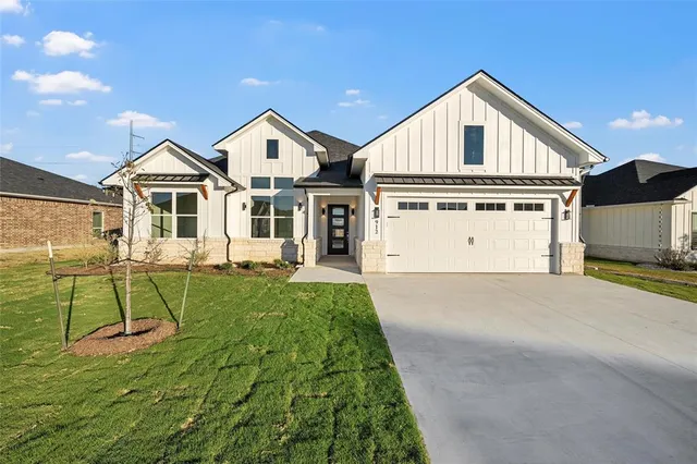 a view of a house with a yard and potted plants