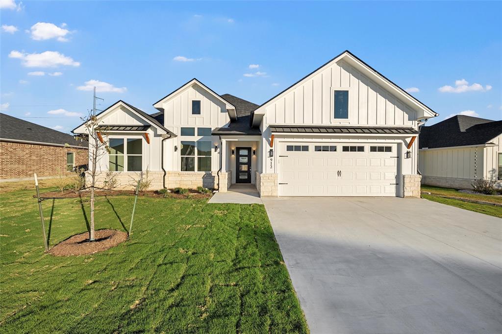 a view of a house with a yard and potted plants