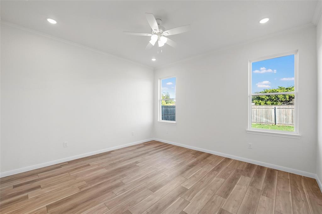 912 Gallant Fox Hewitt, TX 76643 - Photo 9 of 31 an empty room with wooden floor chandelier fan and windows