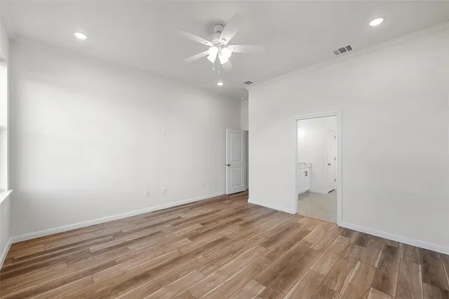 a large room with kitchen view and wooden floor