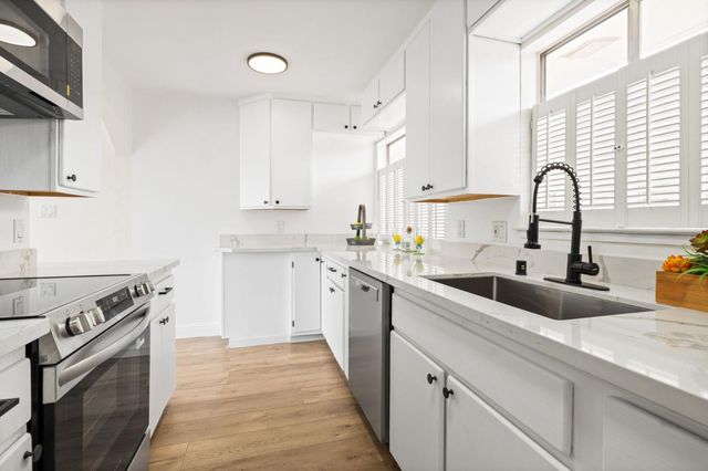 a kitchen with white cabinets and appliances