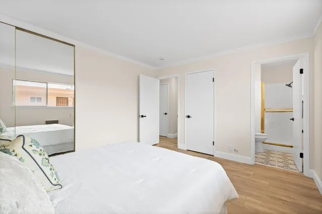 a bedroom with a bed and a large mirror