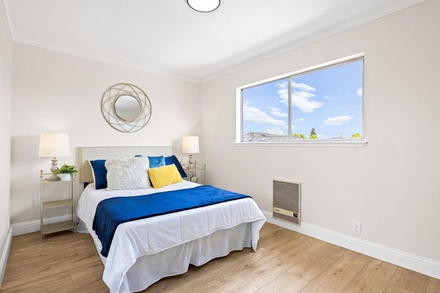 a bedroom with a bed and a painting on the wall