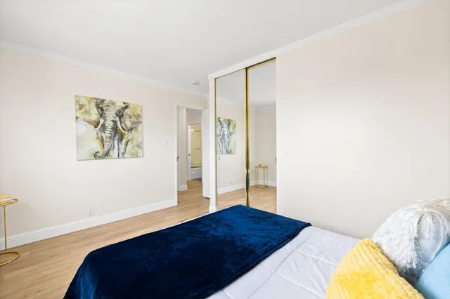 a bedroom with a bed and a painting on the wall