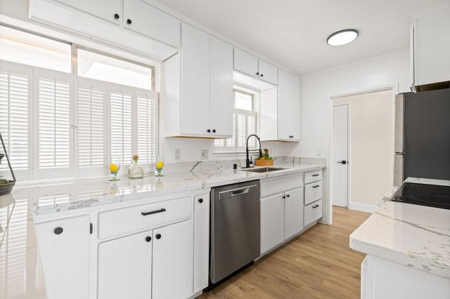 a kitchen with sink a window and stainless steel appliances