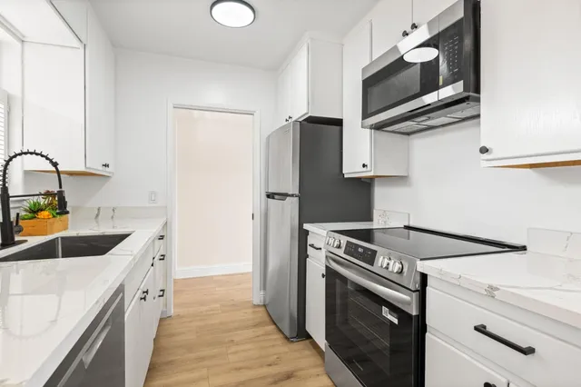 a kitchen with stainless steel appliances granite countertop a sink stove and refrigerator