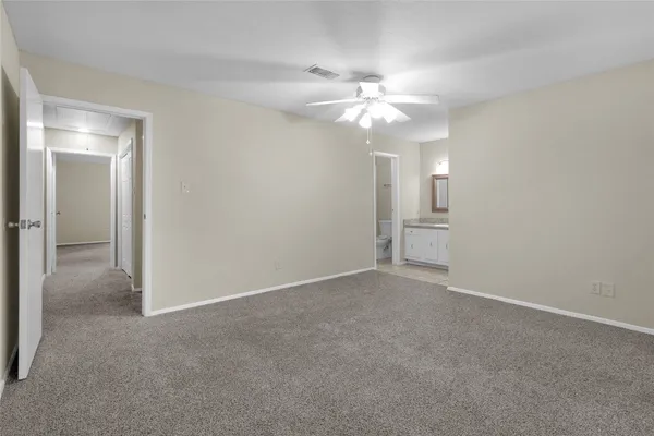 a view of an empty room with a chandelier fan