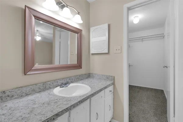a bathroom with a granite countertop sink and a mirror