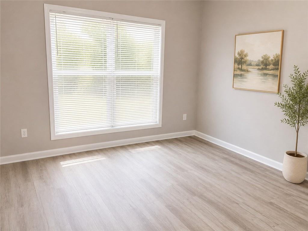 865 McDonough Road Hampton, GA 30228 - Photo 7 of 8 a view of an empty room with wooden floor and a window
