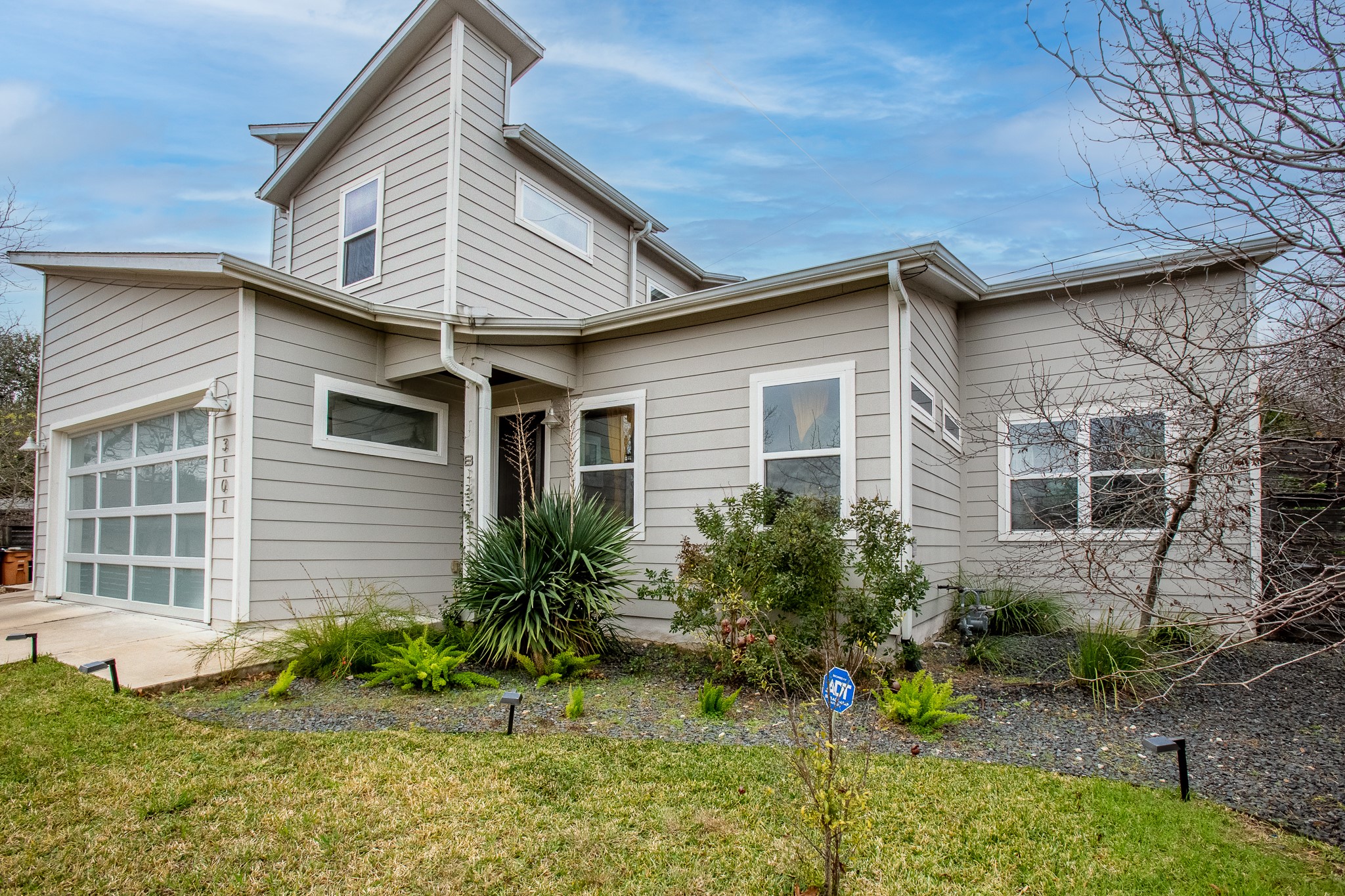 View of front of property featuring a garage and a front yard
