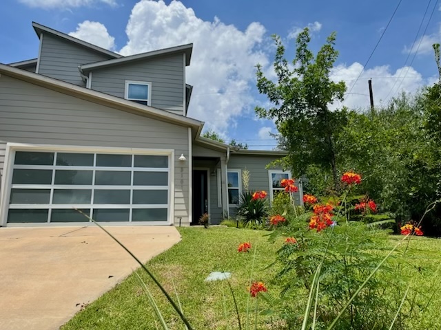 3101 Sunnylawn Circle, Unit B Austin, TX 78723 - Photo 28 of 32 View of front of home featuring a front lawn, concrete driveway, and a garage