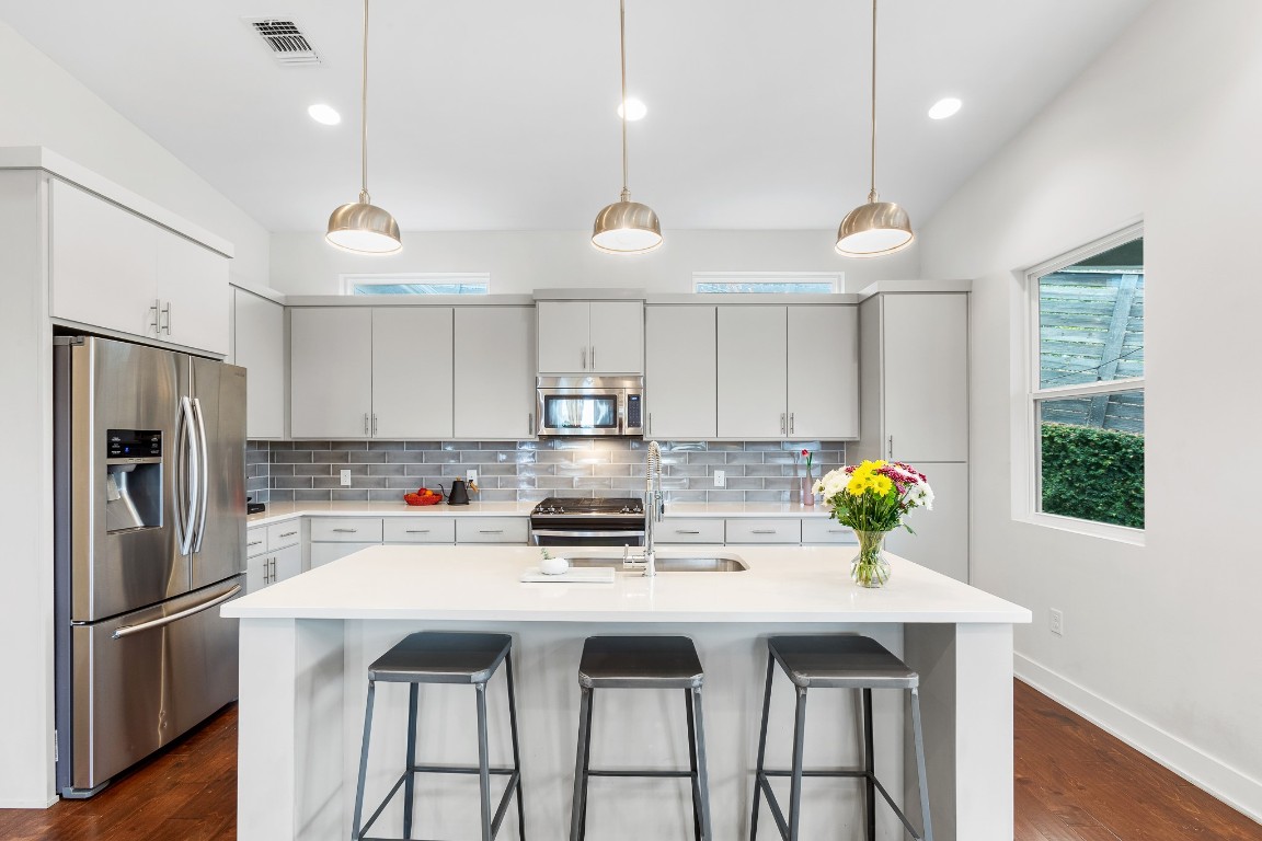 3101 Sunnylawn Circle, Unit B Austin, TX 78723 - Photo 7 of 28 Kitchen with stainless steel appliances, decorative light fixtures, a breakfast bar, and recessed lighting