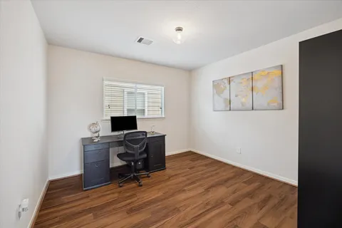a view of a workspace with furniture and a window