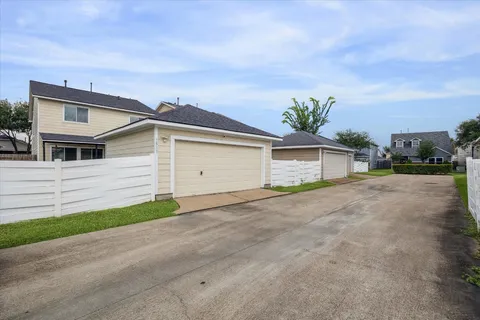 a view of garage yard and car parked on road