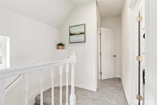 a view of a hallway with a white walls and wooden floor