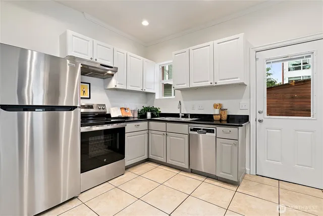 a kitchen with stainless steel appliances granite countertop a refrigerator sink and stove
