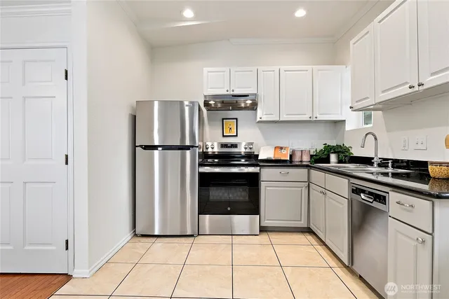 a kitchen with stainless steel appliances granite countertop a refrigerator and a stove top oven