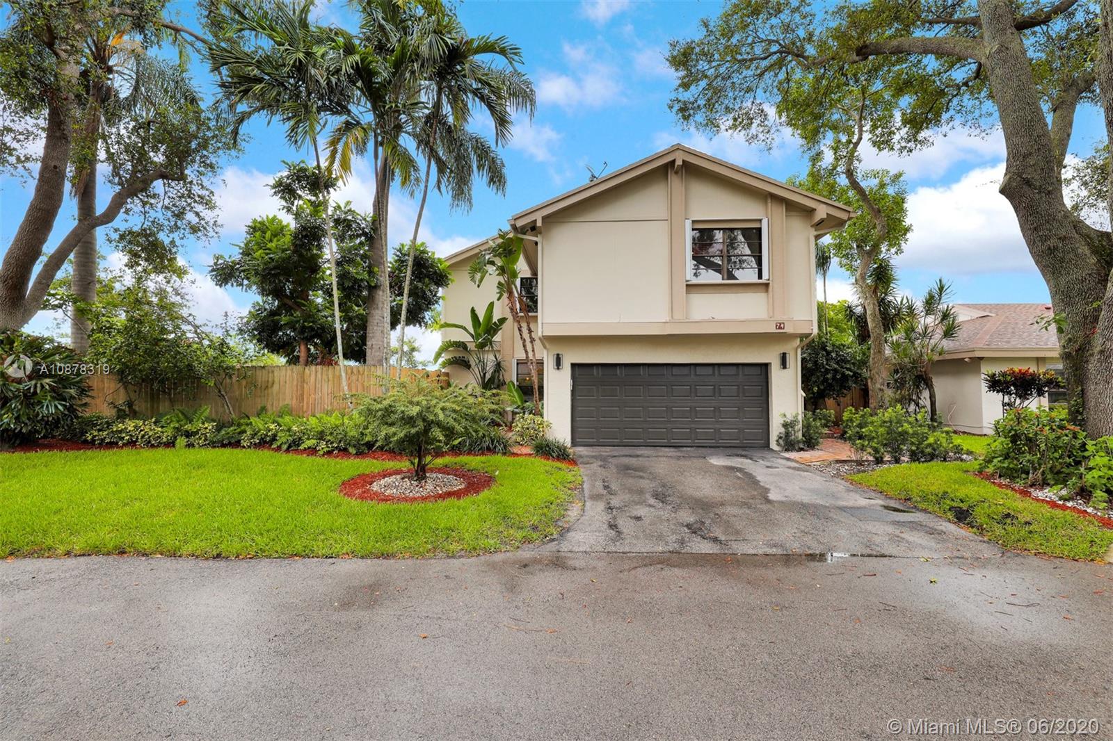 a front view of a house with a garden and yard
