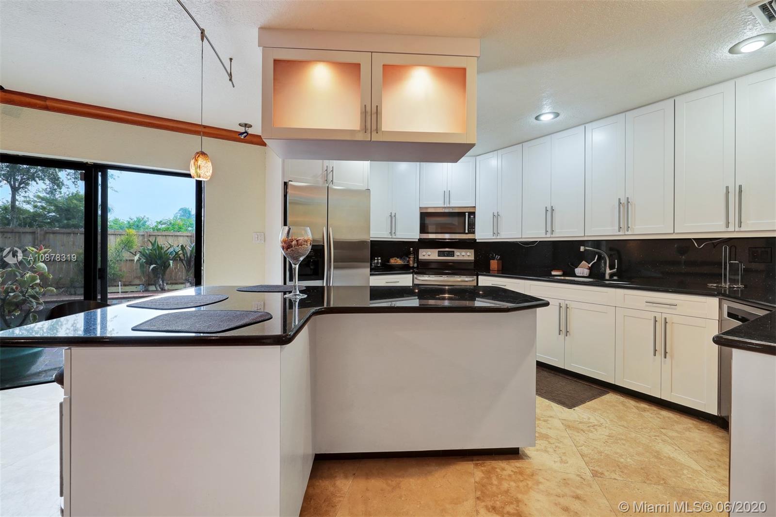 74 Ivy Road Hollywood, FL 33021 - Photo 14 of 55 a kitchen with stainless steel appliances granite countertop a sink and white cabinets