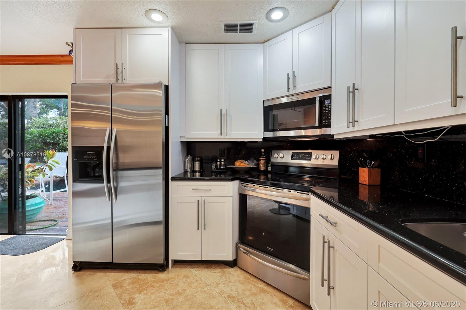 74 Ivy Road Hollywood, FL 33021 - Photo 16 of 55 a kitchen with stainless steel appliances granite countertop a refrigerator a microwave a sink and cabinets