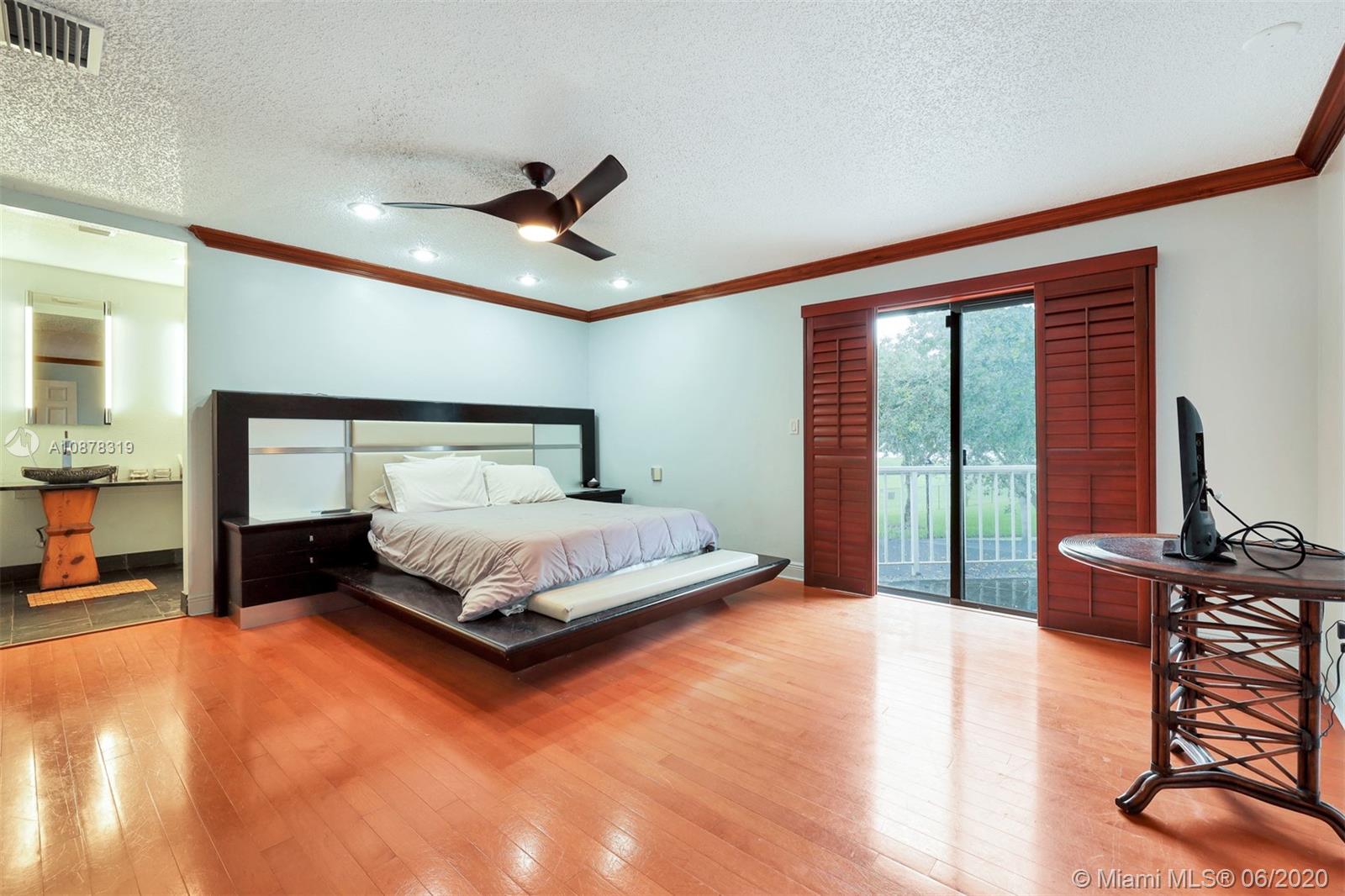 74 Ivy Road Hollywood, FL 33021 - Photo 26 of 55 a bedroom with a large bed and a chandelier
