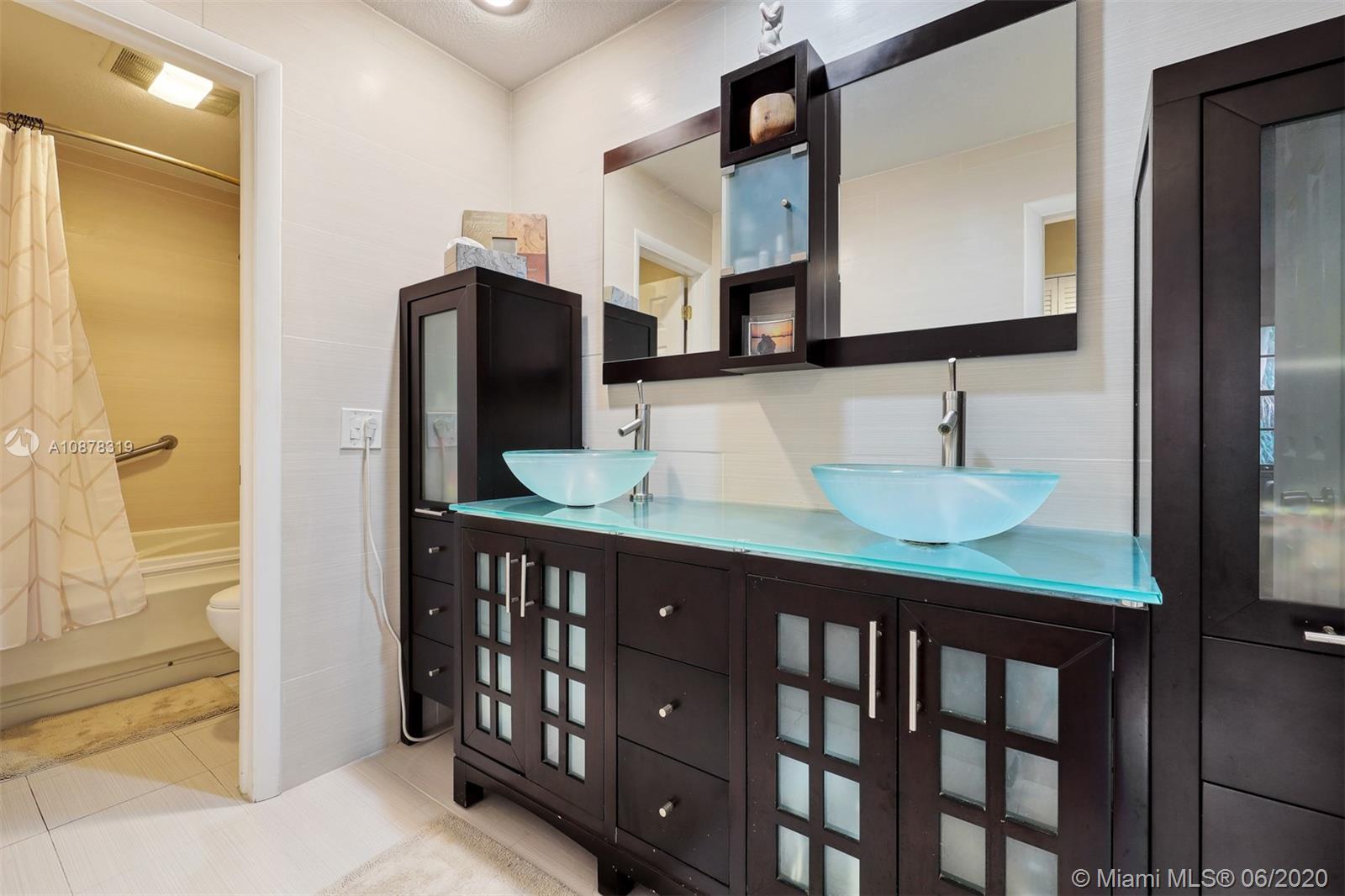 74 Ivy Road Hollywood, FL 33021 - Photo 36 of 55 a bathroom with a sink a mirror and a shower