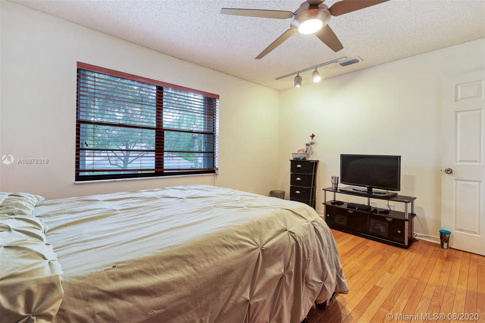 74 Ivy Road Hollywood, FL 33021 - Photo 39 of 55 a bedroom with a bed and a flat tv screen on dresser