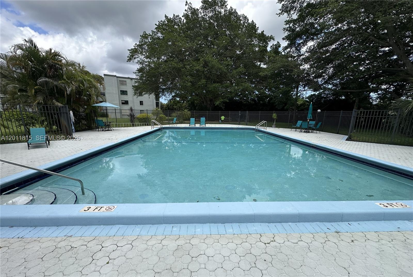 9370 Southwest 8th Street, Unit 107 Boca Raton, FL 33428 - Photo 14 of 17 a view of a swimming pool with a lounge chairs